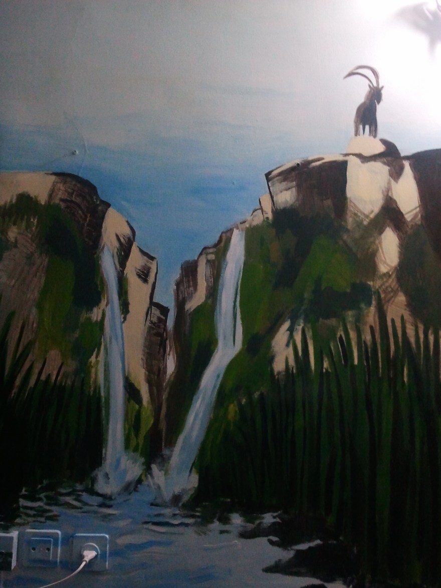 The canyon waterfall mural with an ibex standing on the cliff edge above the falls
