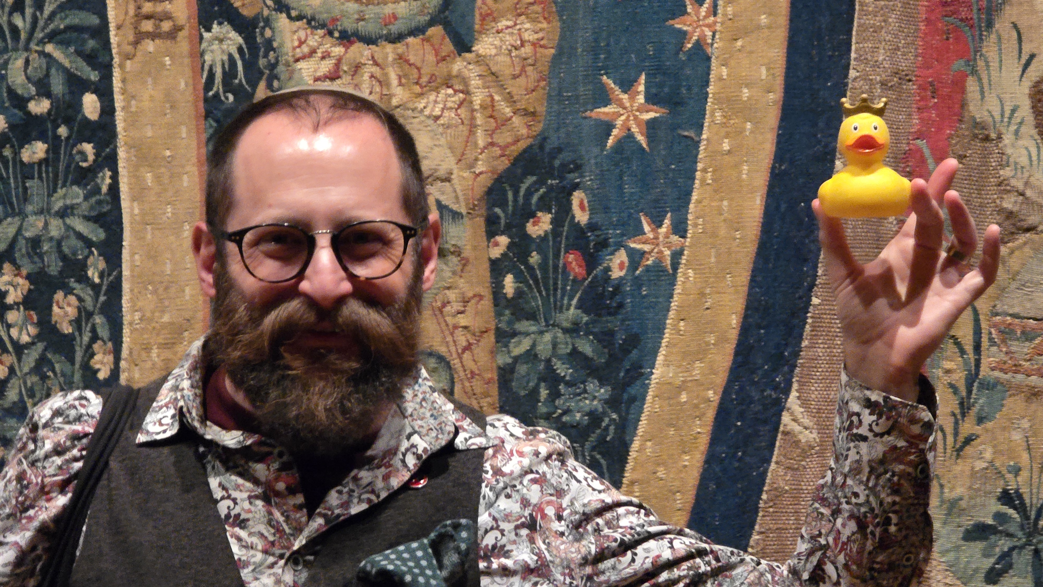 Nachliel Selavan in front of a tapestry at the Getty